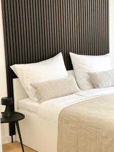 巴什卡沃达SOL Baška Voda的一张带白色枕头和黑色床头板的床