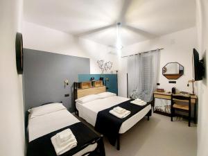 卡梅罗塔码头Don Mario Aparthotel & Rooms的一间卧室配有两张床和一张带镜子的书桌
