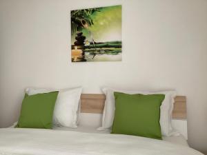 奥托佩尼Relaxing Bucharest Airport Residences & Therme-SELF CHECK-IN的一间卧室配有一张带两个绿色枕头的床