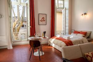 诺沃Superbe appartement de charme à 10mn de Saint-Rémy的一间卧室配有一张床、一张桌子和一个窗户。