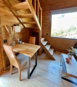 丰沙尔Mountain Eco Shelter 6的小木屋内的木制客房,配有桌椅