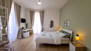 锡拉库扎Fortuna Guest House的白色卧室设有床、书桌和窗户