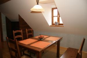 科斯塔涅维察Apartmaji Žolnir的天花板的客房内配有一张木桌和椅子