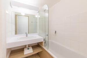 普罗旺斯艾克斯Appart'City Classic Aix-en-Provence - La Duranne的白色的浴室设有水槽和淋浴。