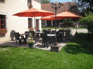 Les Combes拉莫特旅馆的一个带桌椅和遮阳伞的庭院