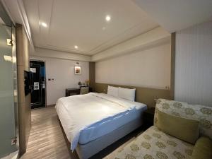 台北世聯商旅的一间卧室配有一张大床和一张沙发