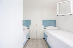RogačićPerina Haven - Island Vis Beachfront的白色和蓝色的客房内的两张床