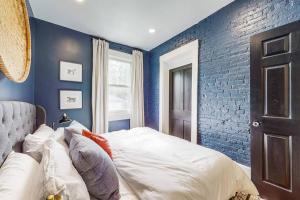 路易斯威尔Luxury 8 Bed/4 Ba NuLu Home Private yard/parking的一间卧室拥有蓝色的墙壁,配有一张带枕头的床。