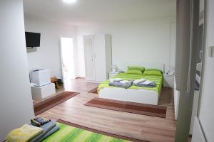 克拉多沃Rooms Busujok的一间卧室配有一张带绿毯的床