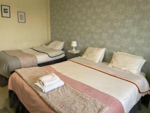 布拉加Liber Guest House的两张位于酒店客房的床,配有毛巾
