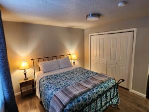 安克雷奇Nightshade BnB的一间卧室配有一张床、两盏灯和一扇门