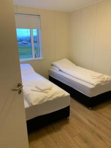 HafnirGhost Town Guest House 10 min from Airport的小型客房 - 带2张床和窗户
