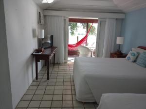 布希奥斯Barracuda Eco Resort Búzios的一间卧室配有一张床、一张书桌和一张书桌