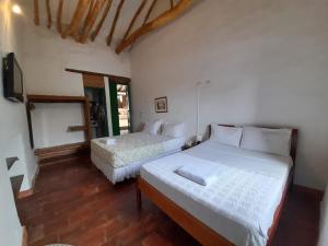 巴里查拉Posada Sueños de Antonio的一间卧室配有两张床和一台平面电视
