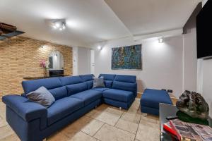 罗马Oliviero - Piazza Navona Apartment的客厅里设有蓝色的沙发,设有砖墙