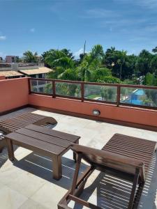 皮帕Flat com Terraço Pipa Beleza Resort的阳台的天井配有桌子和长凳
