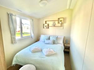 波斯考尔Trecco bay caravan hire 4 bedrooms sleeps 10的一间卧室配有一张床,上面有两条毛巾