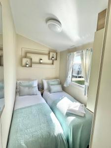 波斯考尔Trecco bay caravan hire 4 bedrooms sleeps 10的小型客房 - 带2张床和窗户