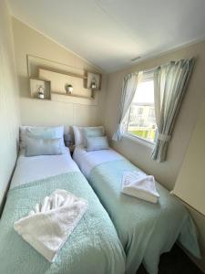 波斯考尔Trecco bay caravan hire 4 bedrooms sleeps 10的小型客房 - 带2张床和窗户