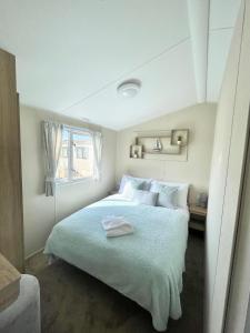 波斯考尔Trecco bay caravan hire 4 bedrooms sleeps 10的白色卧室配有一张带白色枕头的大床