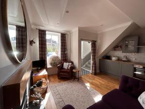 邓布兰The Cottage的带沙发的客厅和厨房