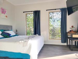 玛志洛Beachside One Bedroom Flat Retreat的一间卧室设有一张大床和两个窗户。