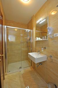 斯普利特Guesthouse Villa Vice的带淋浴、水槽和玻璃淋浴间的浴室