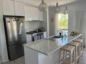 Nepean BayBeachfront 4 Bedroom Home in Nepean Bay的厨房配有不锈钢冰箱和白色橱柜