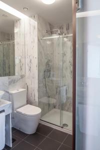里斯本Luzeiros Suites的带淋浴、卫生间和盥洗盆的浴室