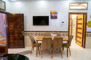 阿加迪尔Riad dar asalam的一间带桌椅和电视的用餐室