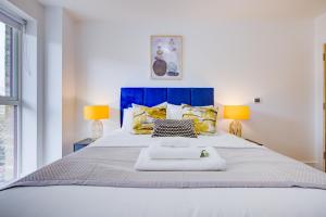 伦敦Luxe Apartment by Excel的一间卧室配有一张带两盏灯的大型白色床。