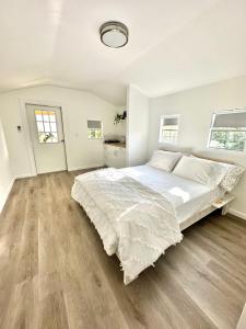 迈阿密Beach guests house的白色卧室设有一张大床和木地板