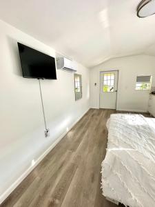 迈阿密Beach guests house的卧室配有一张床和壁挂式平面电视。