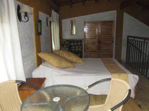 波特雷里约斯Cabañas Los Arreboles的一间卧室配有一张带玻璃桌和椅子的床
