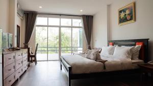 清迈ANANTAYA CHIANGMAI BOUTIQUE HOTEL的一间卧室设有一张床和一个大窗户