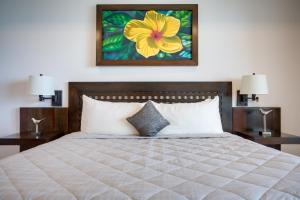 圣佩德罗格兰德加勒比伯利兹度假村的一间卧室配有一张带2个床头柜的大床