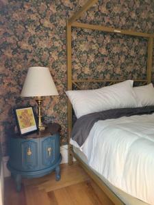 萨塞克斯The Maple Shade Suite的一间卧室配有一张床和一张带台灯的桌子