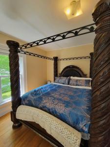 萨塞克斯The Maple Shade Suite的一间卧室配有一张带蓝色棉被的天蓬床