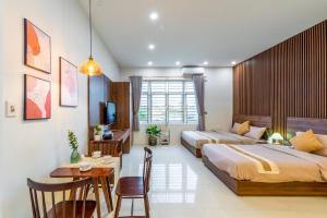 岘港NM Homestay Danang的一间卧室配有两张床、一张桌子和一张书桌