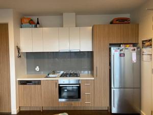 阿斯彭达尔Beach Life的厨房配有不锈钢冰箱和白色橱柜