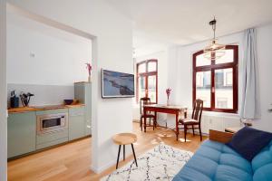 莱比锡casanando - LaMaison - neu saniert in ruhiger Innenstadtlage的一间带蓝色沙发的客厅和一间厨房