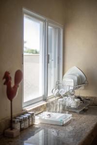 切图马尔Casa privada con alberca grande的带玻璃杯的厨房台面和窗户