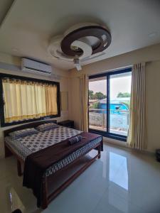 VeshviSukhakarta Holiday Home的一间卧室设有一张床和一个大窗户
