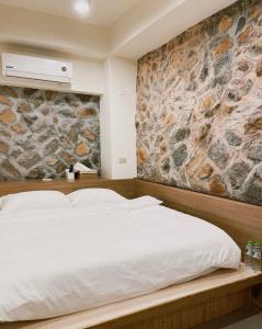 Chung-liu-ts'un小島上二館的卧室配有白色的床铺和石墙