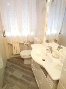 马西亚娜马里纳Appartamento Loretta的白色的浴室设有卫生间和水槽。