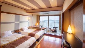 土庄町天空海庐酒店的酒店客房设有两张床和一个阳台。