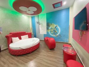 胡志明市HOTEL THU HÀ的一间卧室配有一张床和一张红色椅子