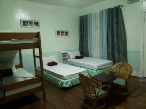 碧瑶老橙木住宿加早餐旅馆的客房设有两张床、椅子和桌子。