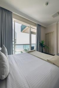 迪拜Al Bateen Residences, Jumeirah Beach Residence - Mint Stay的卧室设有一张大白色的床和大窗户