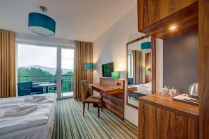 波拉齐克Solina Resort的酒店客房带一张床、一张书桌和一面镜子